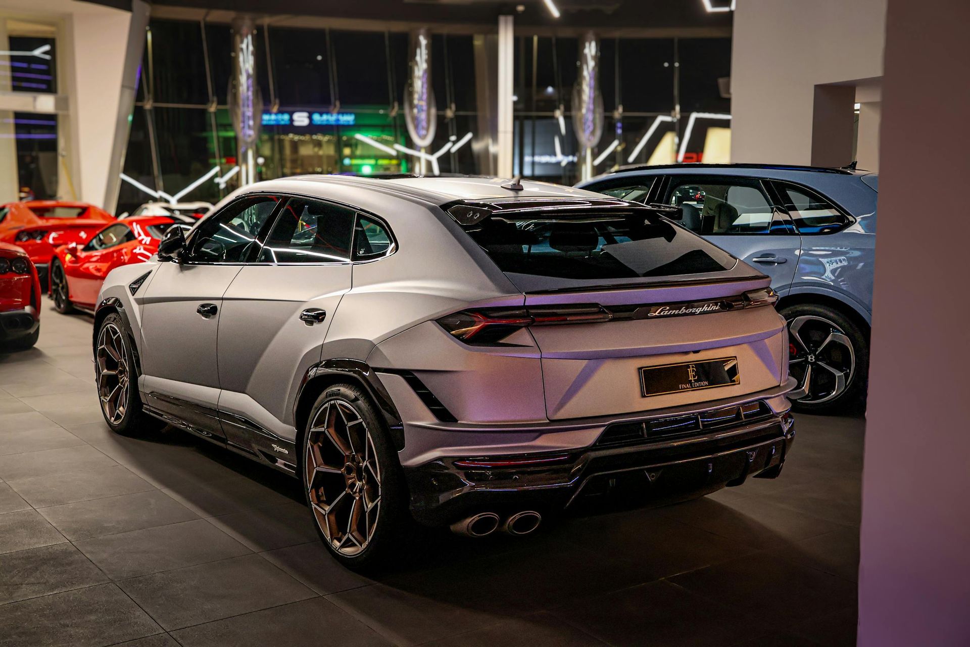SUV Lamborghini cinza em um showroom, com kit de carroceria personalizado e rodas pretas