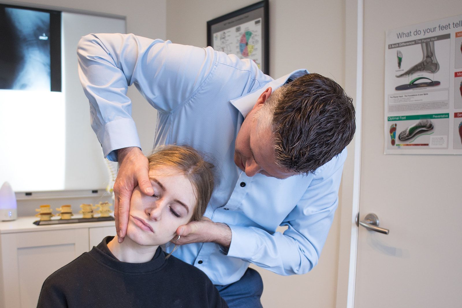 A man adjusting a woman's neck.