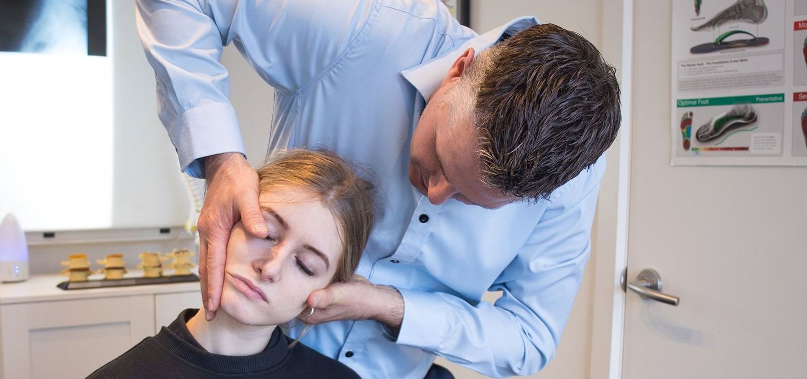 A man is adjusting a woman 's neck.