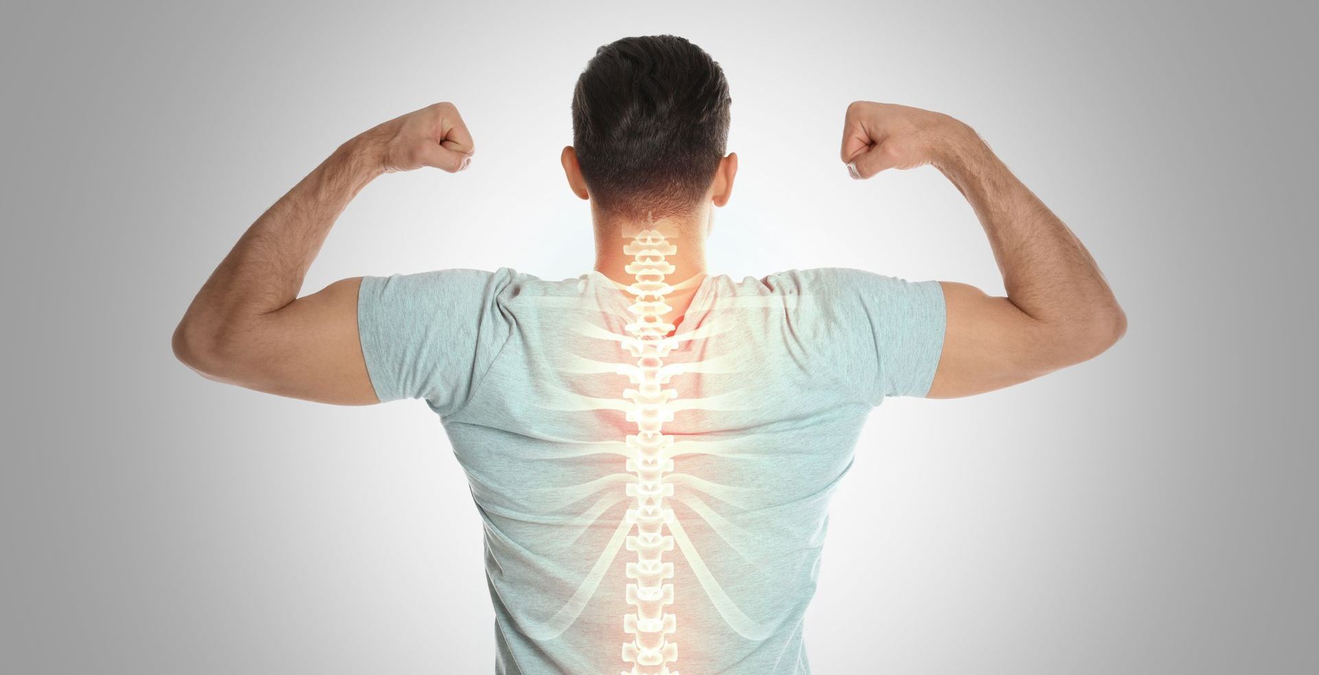 A man is flexing his muscles with a glowing spine on his back.