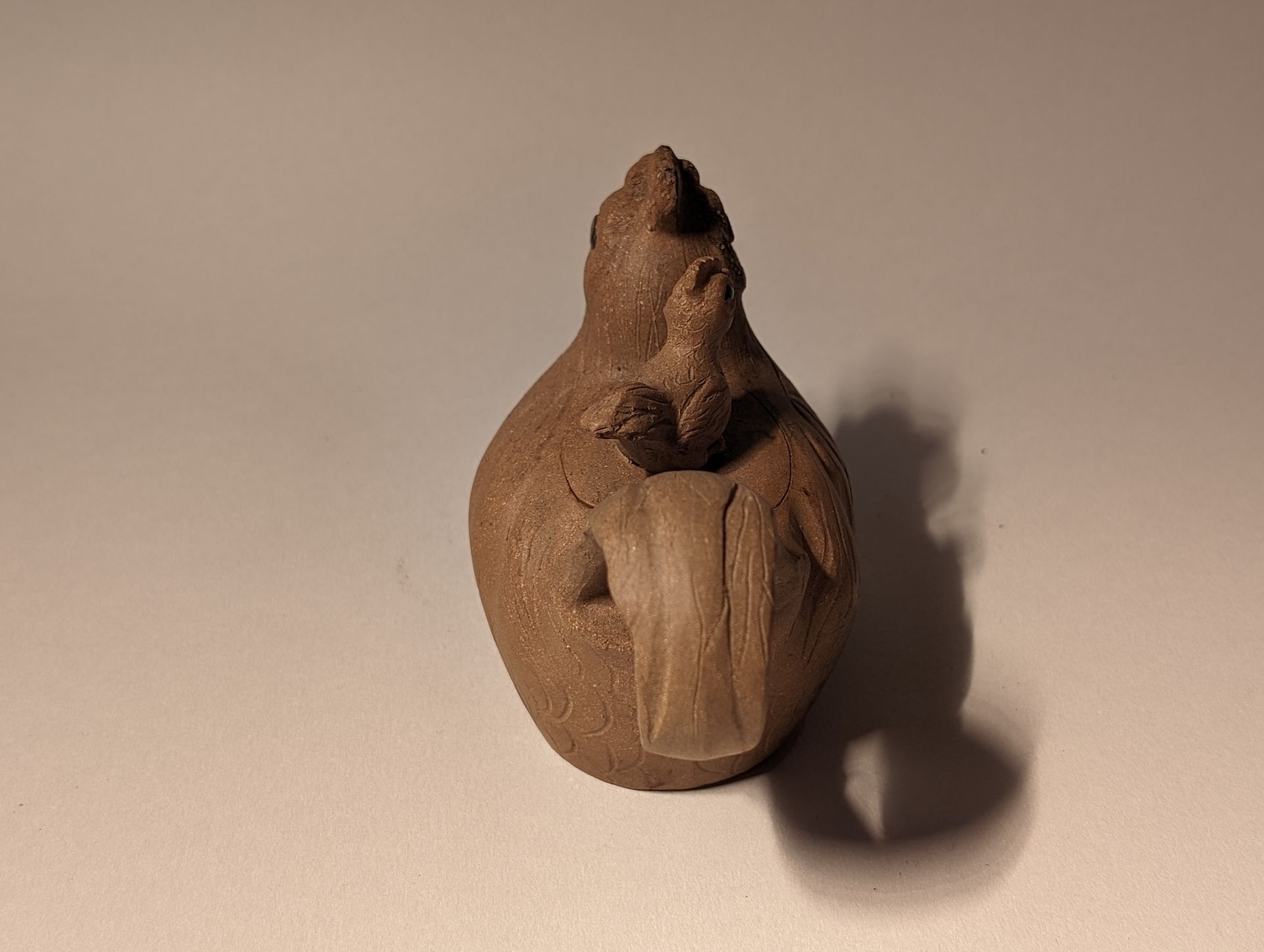 A tea pot of a chicken is sitting on a table