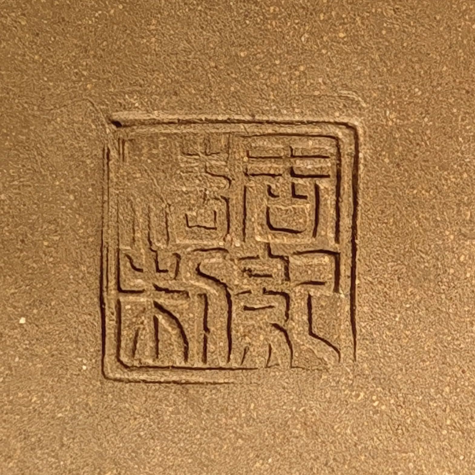 A close up of a piece of clay with a stamp on it.