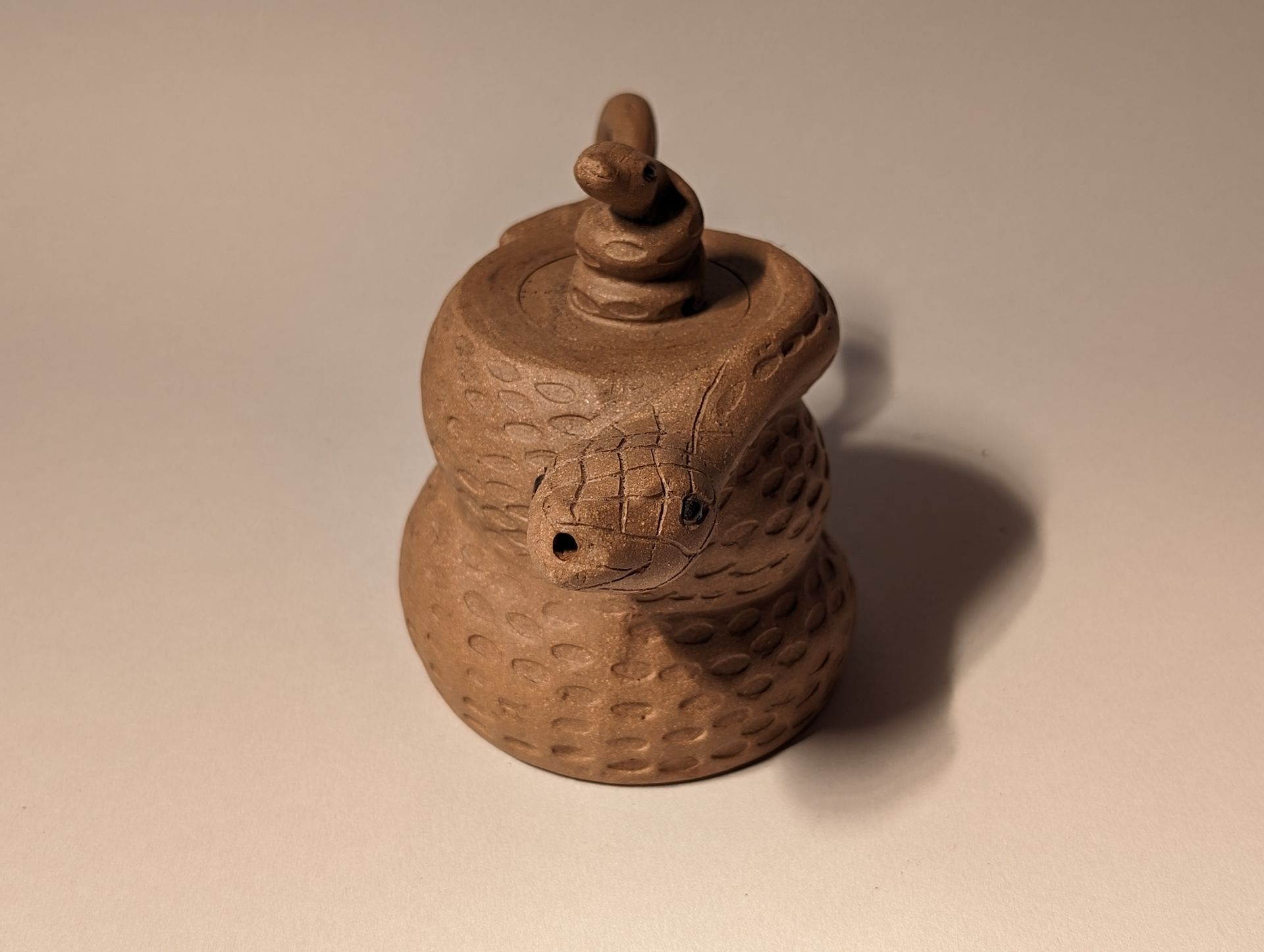 A small brown object with a snake on top of it