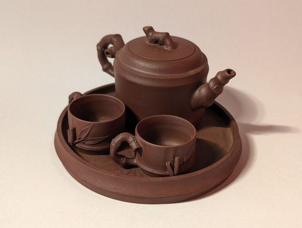 Brown miniature tea set with teapot and two cups on a tray