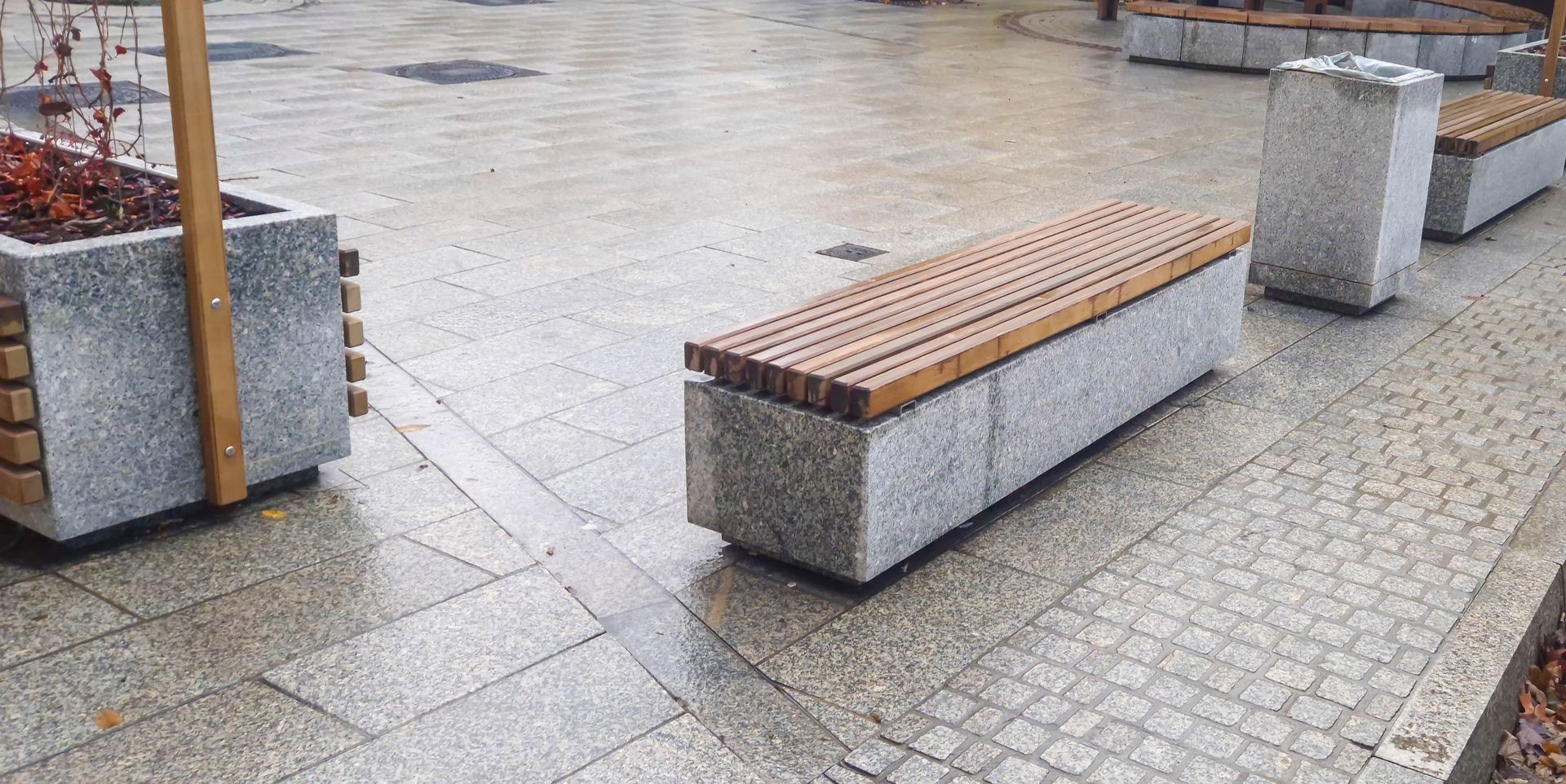 A modern urban park with sleek stone benches.