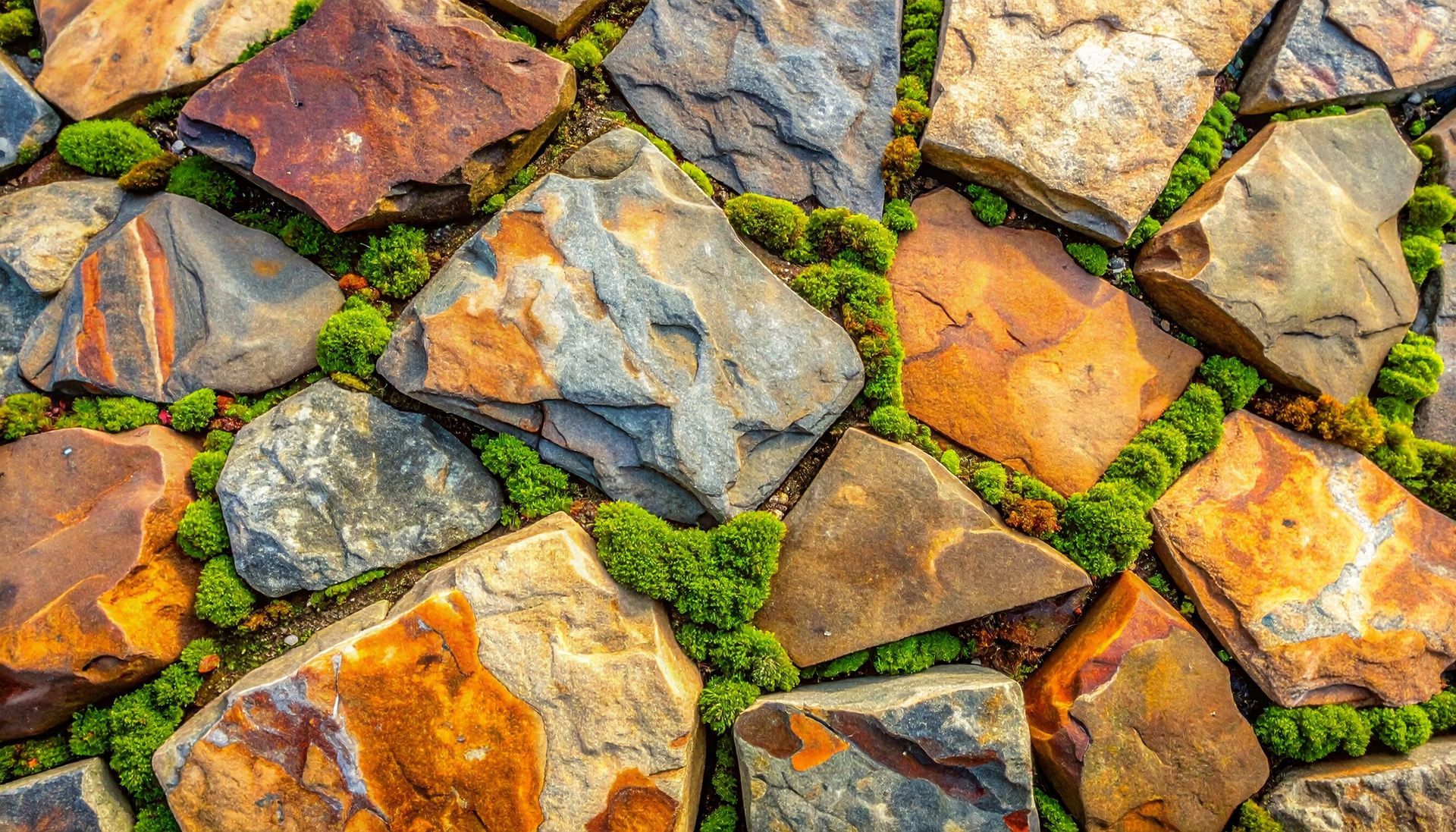Rustic patio with brown, orange, grey, and green stone and moss-accented flagstone
