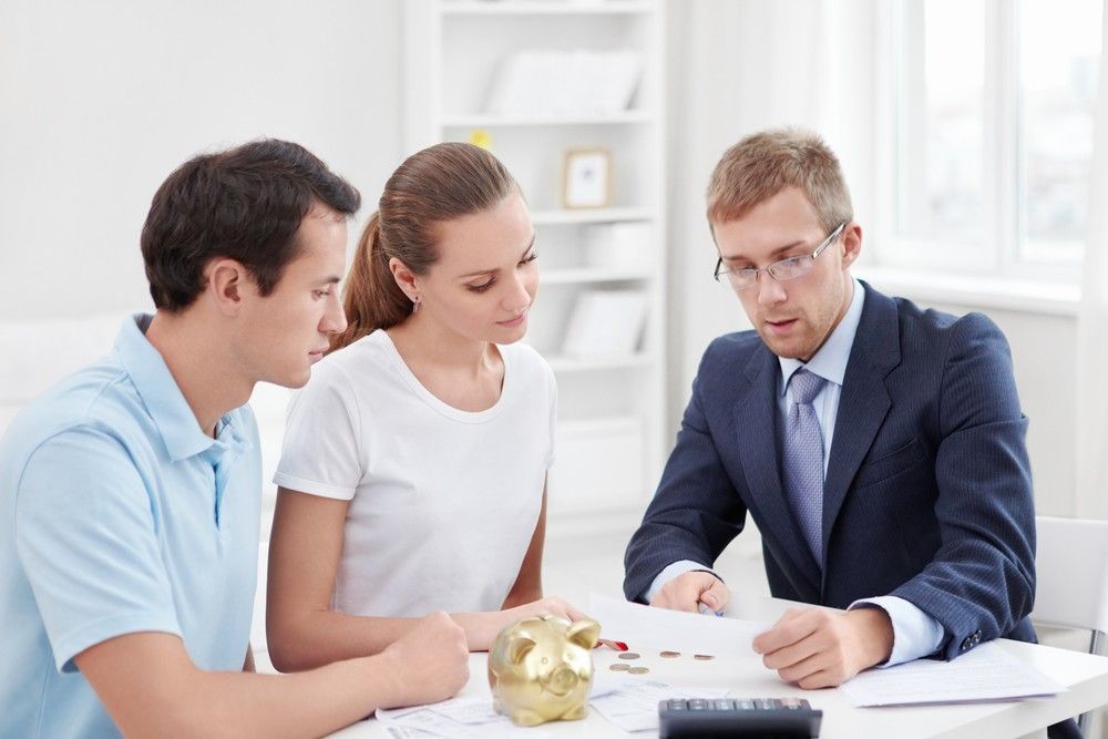 A Man and A Woman Are Sitting at A Table Talking to A Man — Marks Financial Group in  Toowoomba City, QLD