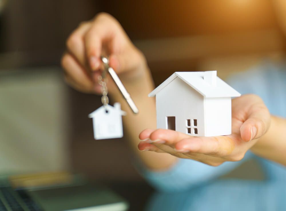 A Person Is Holding a Model House and Keys in Their Hands — Marks Financial Group in  Toowoomba City, QLD