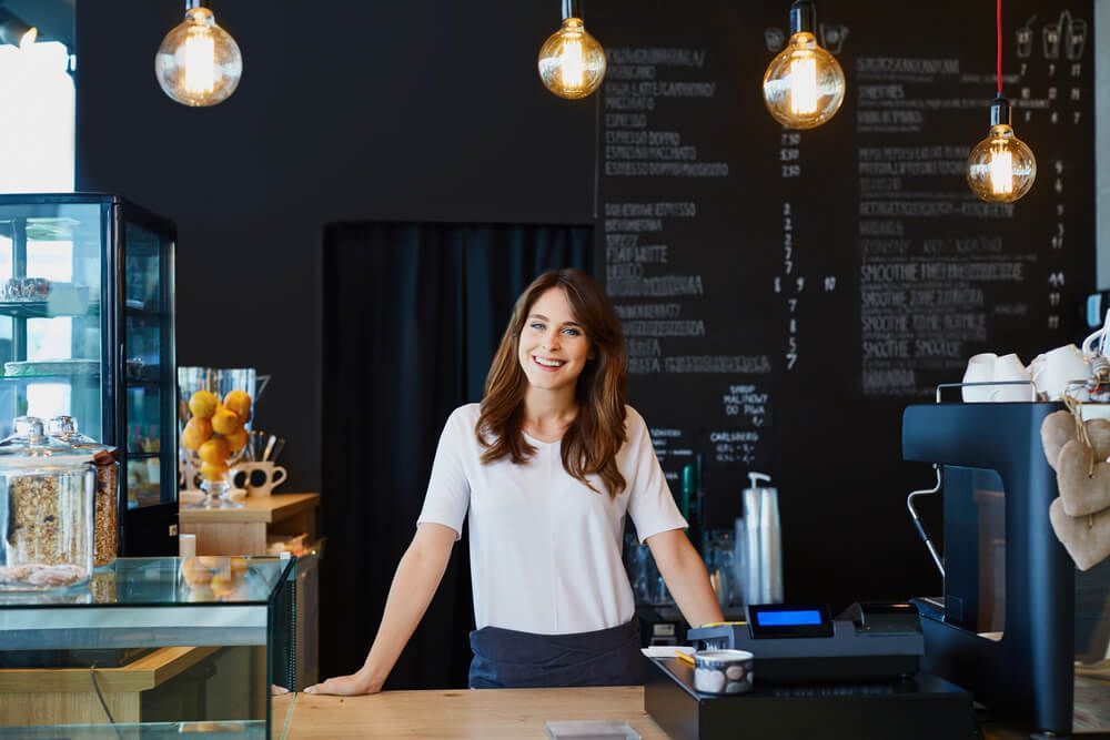 A Woman Is Standing Behind a Counter in A Coffee Shop — Marks Financial Group in Toowoomba City, QLD