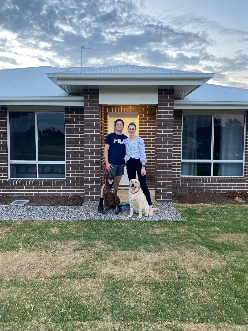 A Man and Woman Are Standing in Front of A Large House — Marks Financial Group in Toowoomba City, QLD