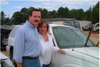 A man and woman standing next to a white car