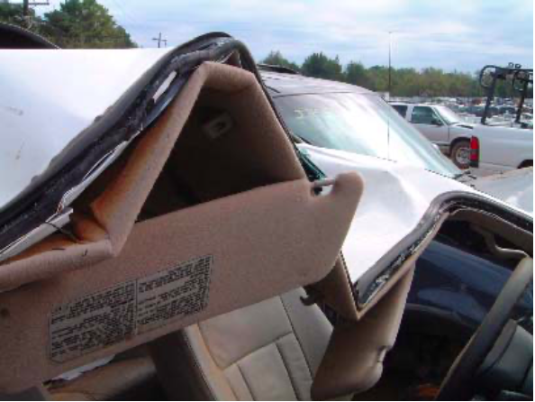 A damaged car with a warning label on the dashboard