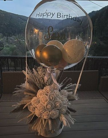 In einem durchsichtigen Ballon hängt ein rotes Hemd mit einem Teddybären darauf.