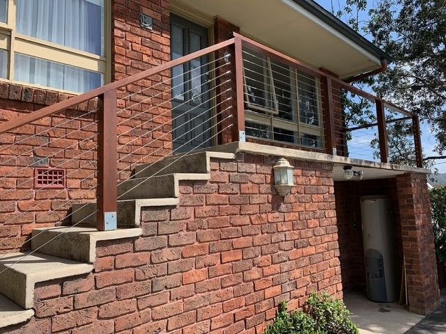 A brick house with stairs leading up to the front door.