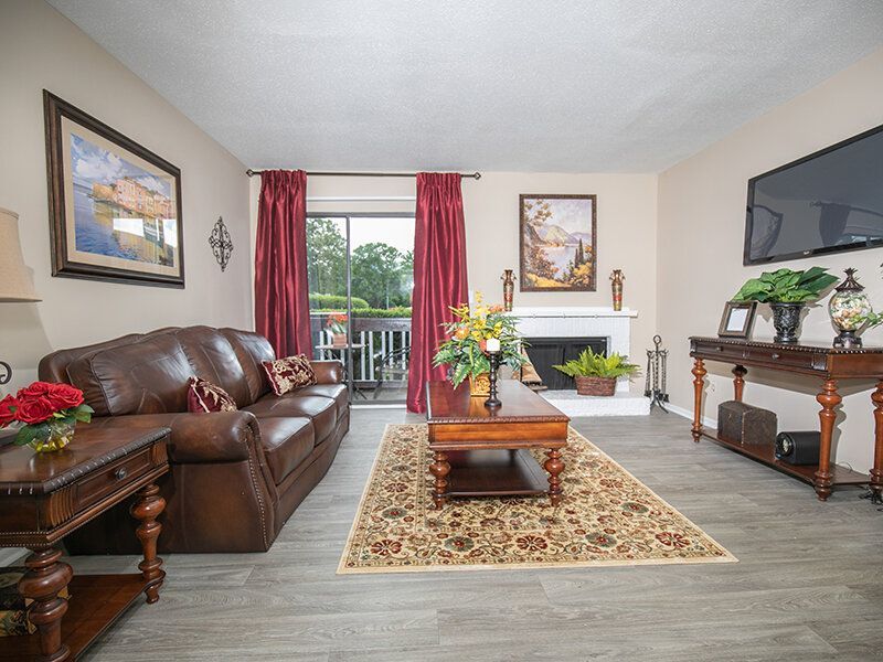Living room with brown leather sofa, fireplace, and balcony access.