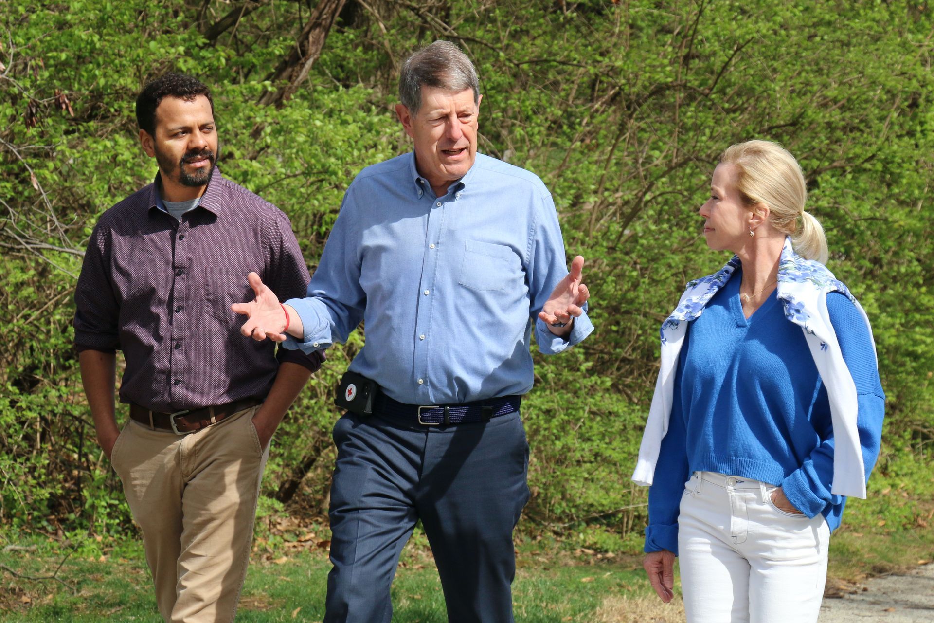 Joe Pereles walking with two other people outside speaking 