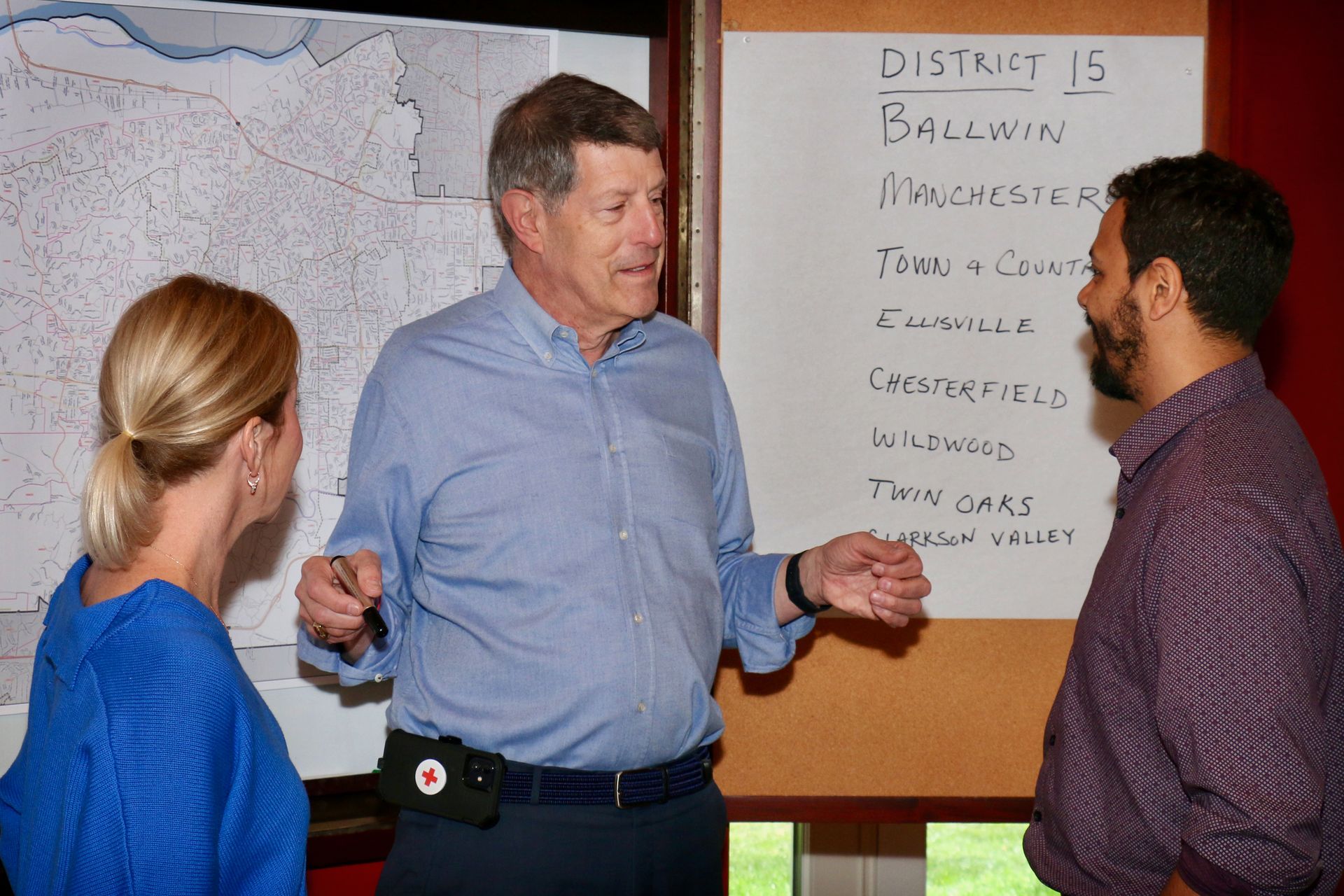 Joe Pereles and two other people are standing in front of a whiteboard that says district 15.