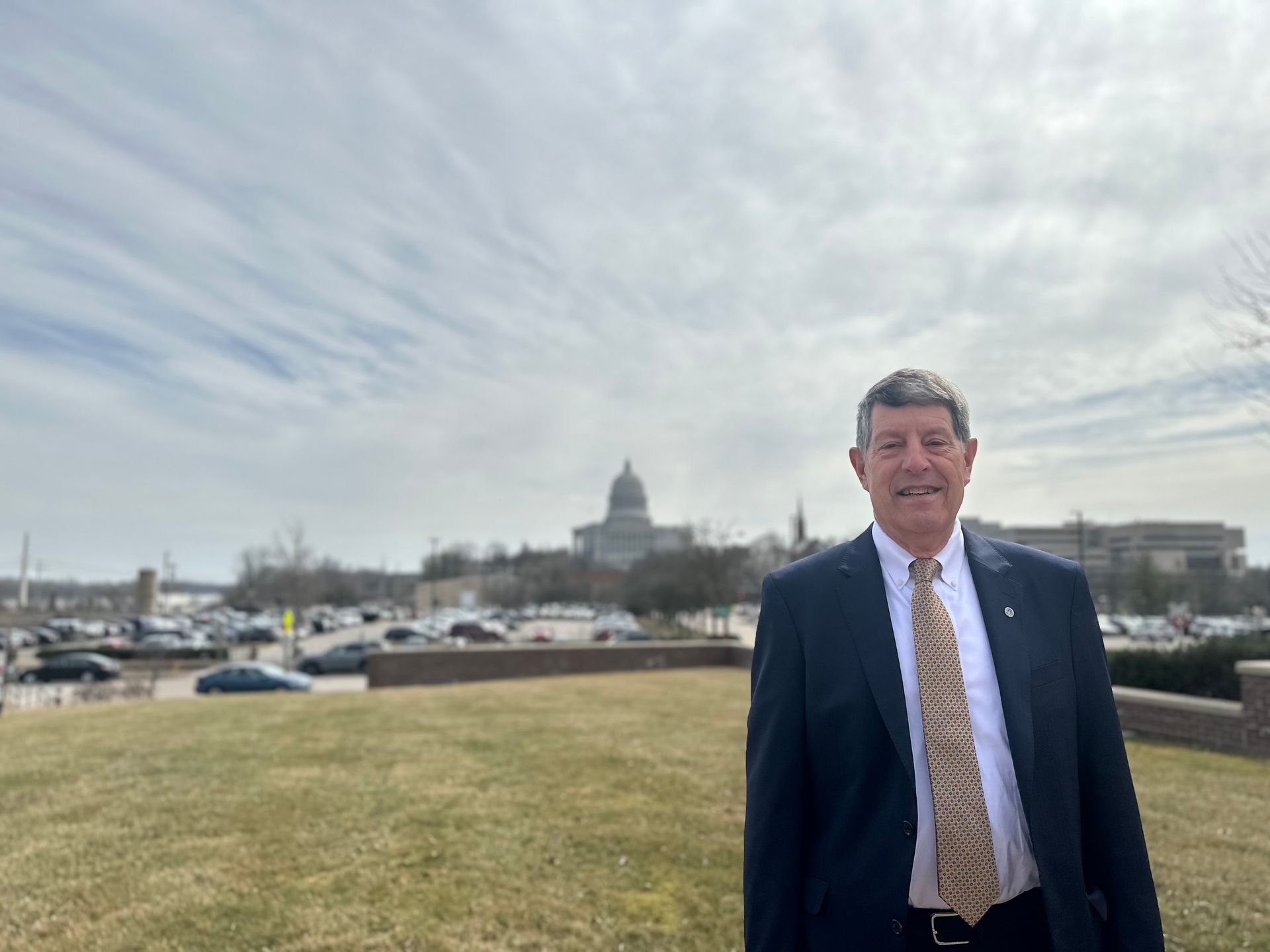 A man in a red shirt is holding a sign that says uaw on strike