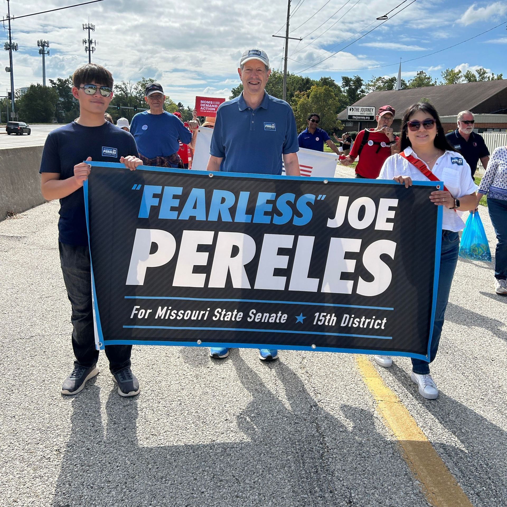 Joe Pereles and supporters at a parade holding a sign that says fearless joe pereles