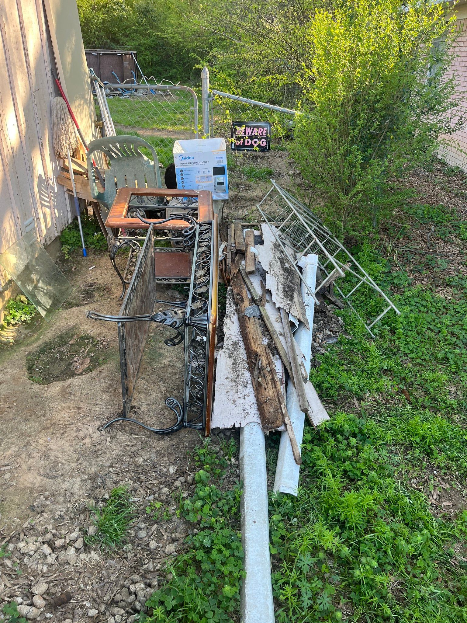 a machine is sitting in the grass next to a fence .