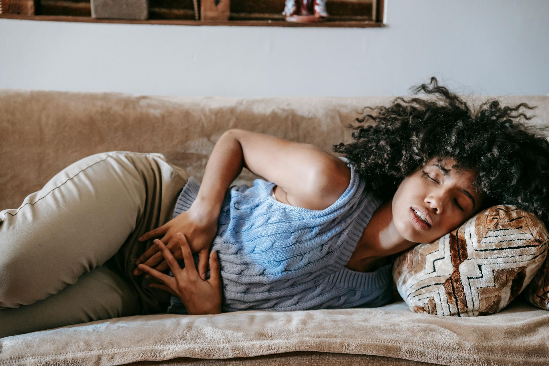 A woman sleeping on a sofa with bladder pain