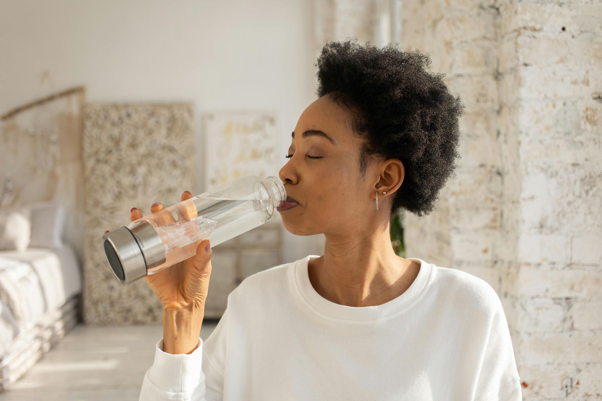 Healthy African adult drinking water at home to support kidney and overall health