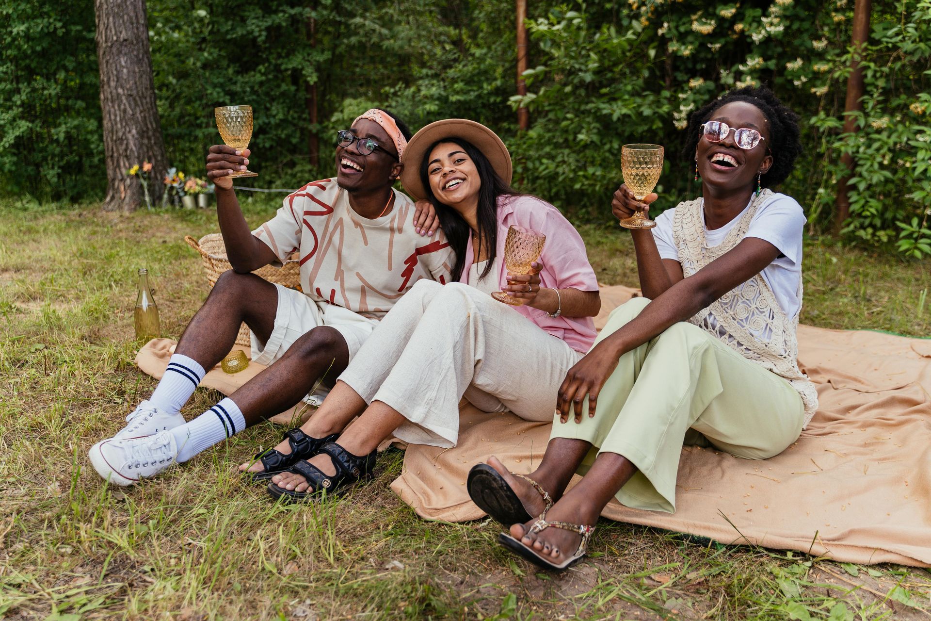 A group of friends having drinks whilst sat on the grass