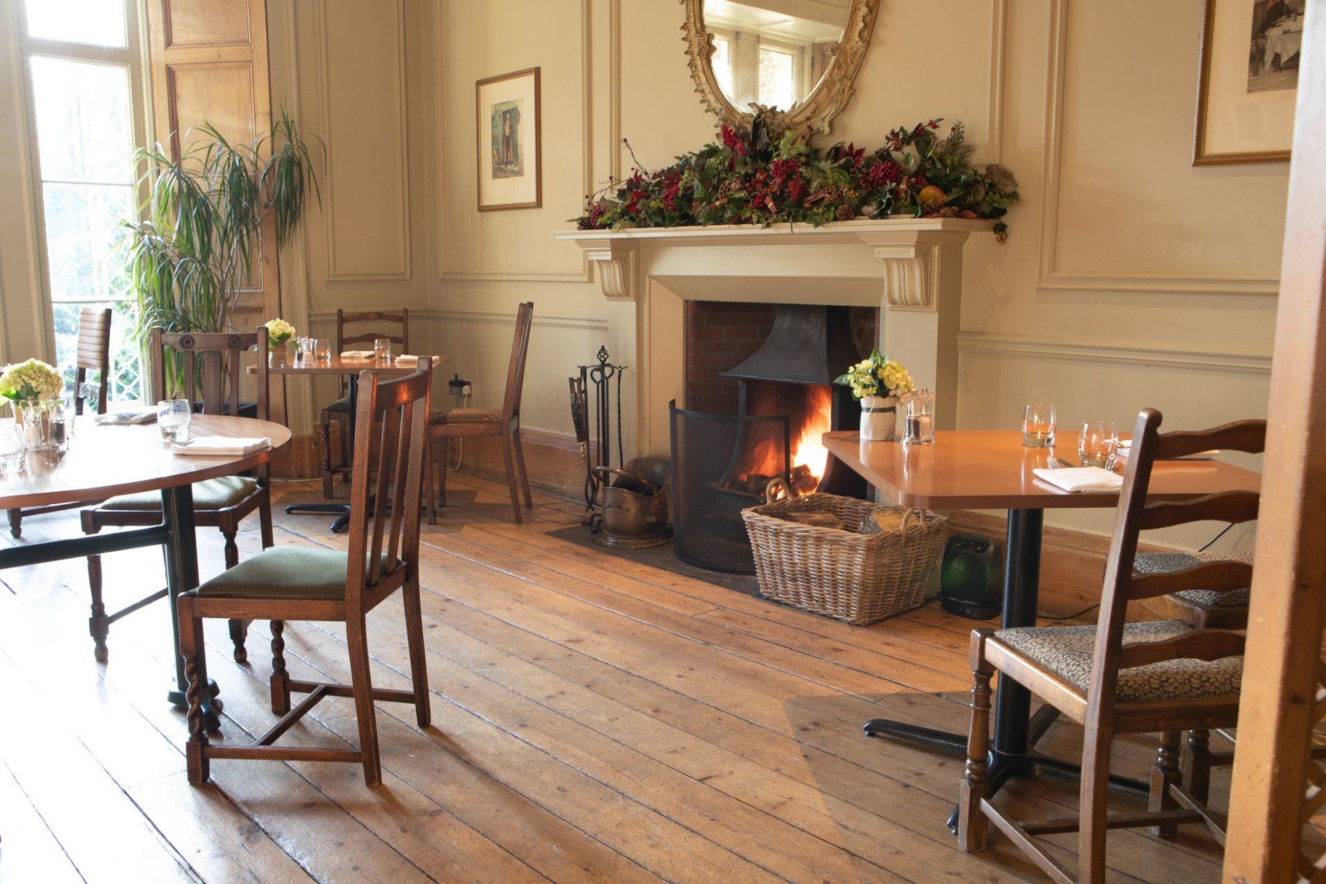 A dining room with tables and chairs and a fireplace