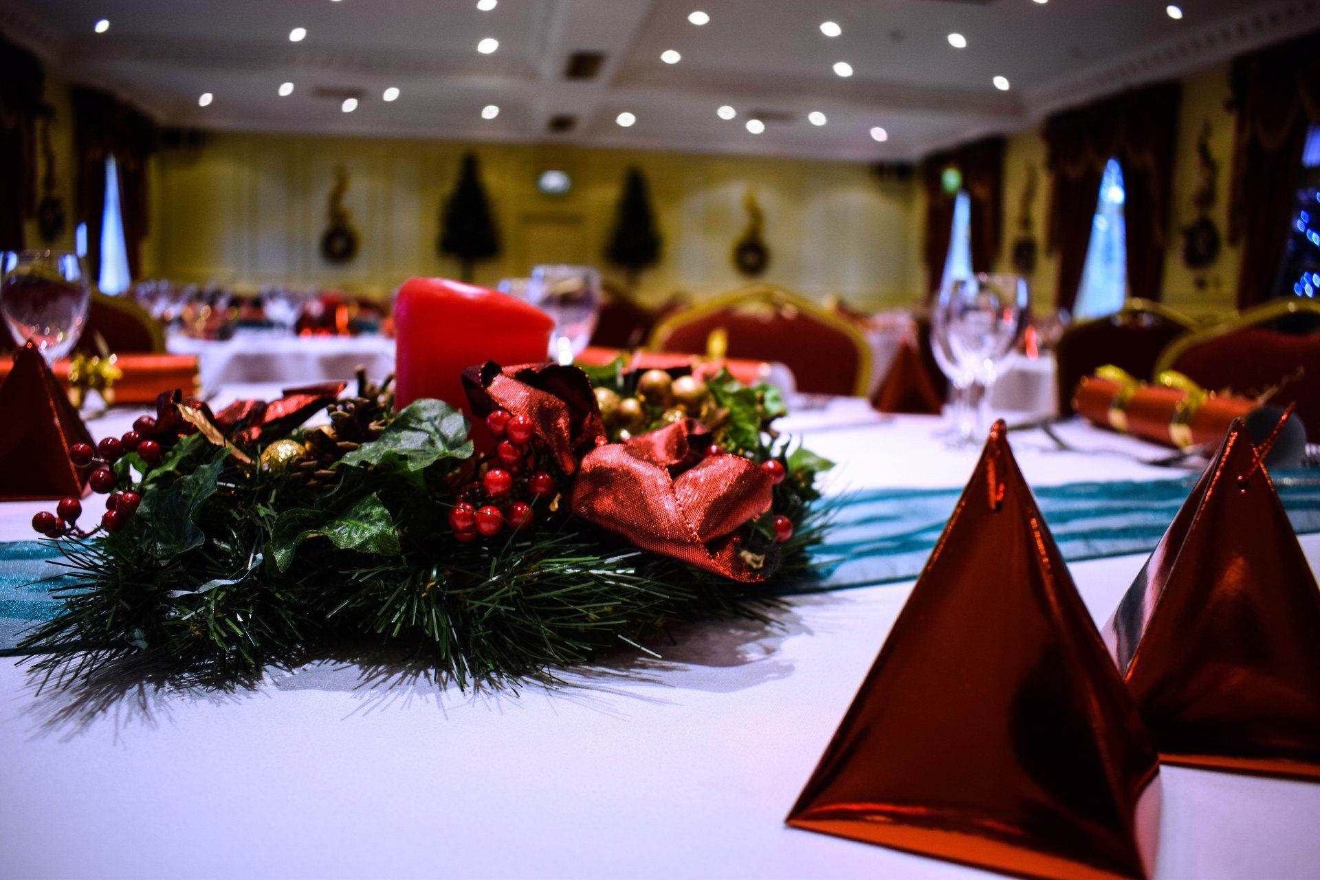 A christmas wreath is sitting on a table in a large room.