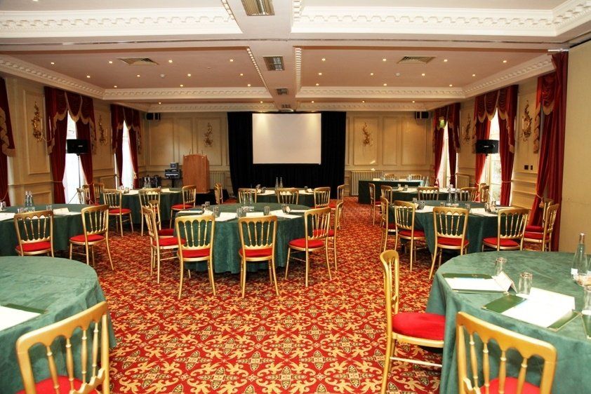 A large room with tables and chairs set up for a meeting
