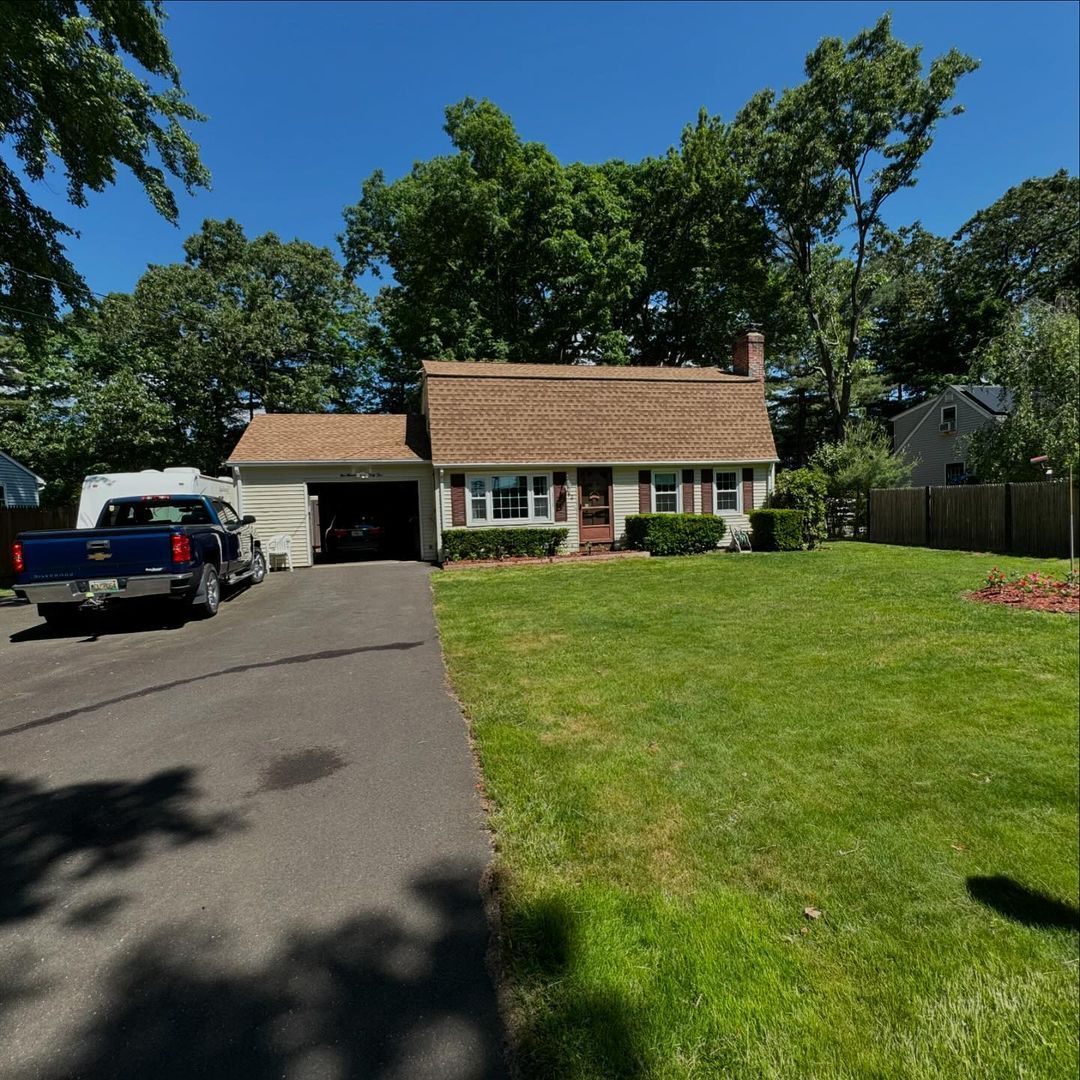A blue truck is parked in front of a house