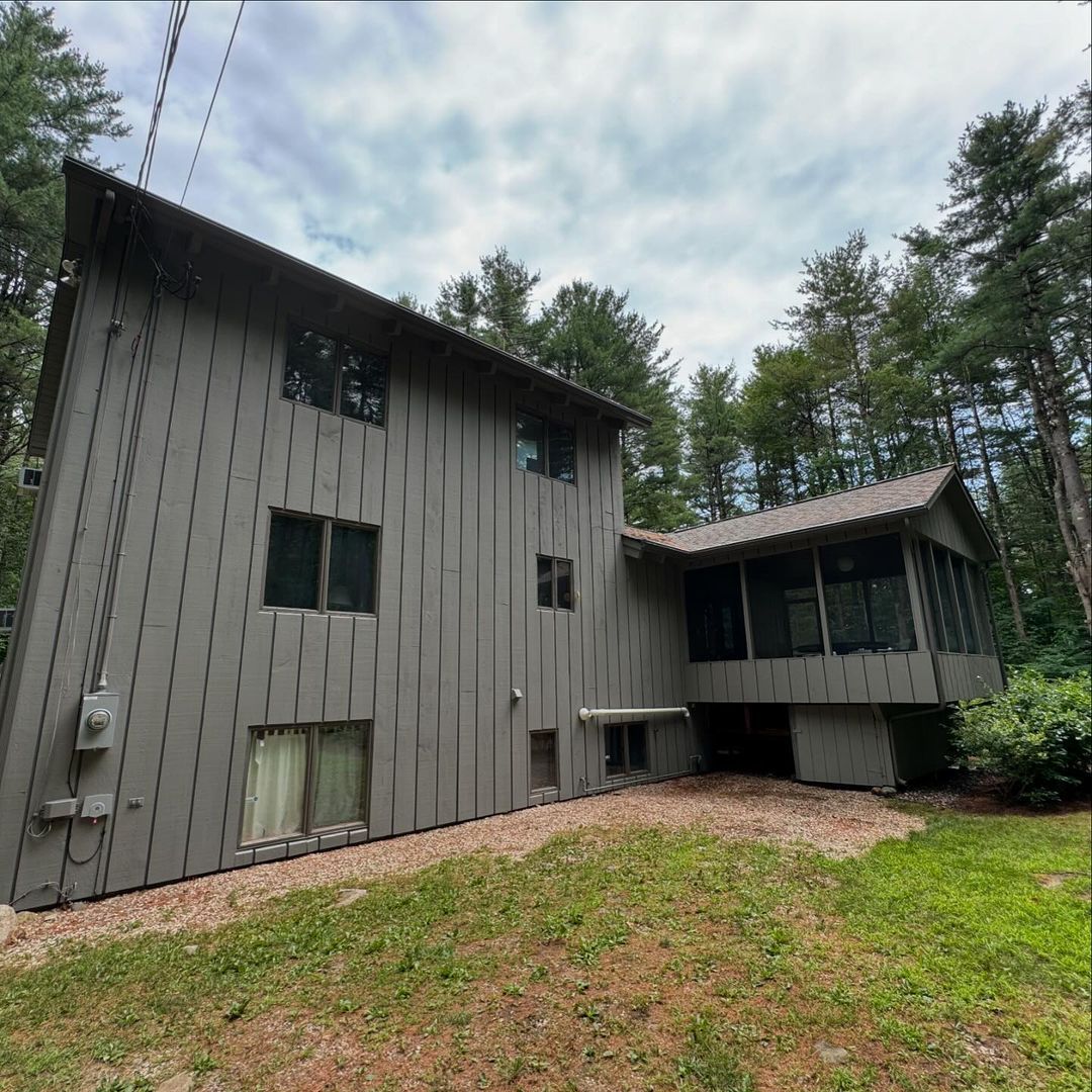 A large house with a lot of windows is surrounded by trees.