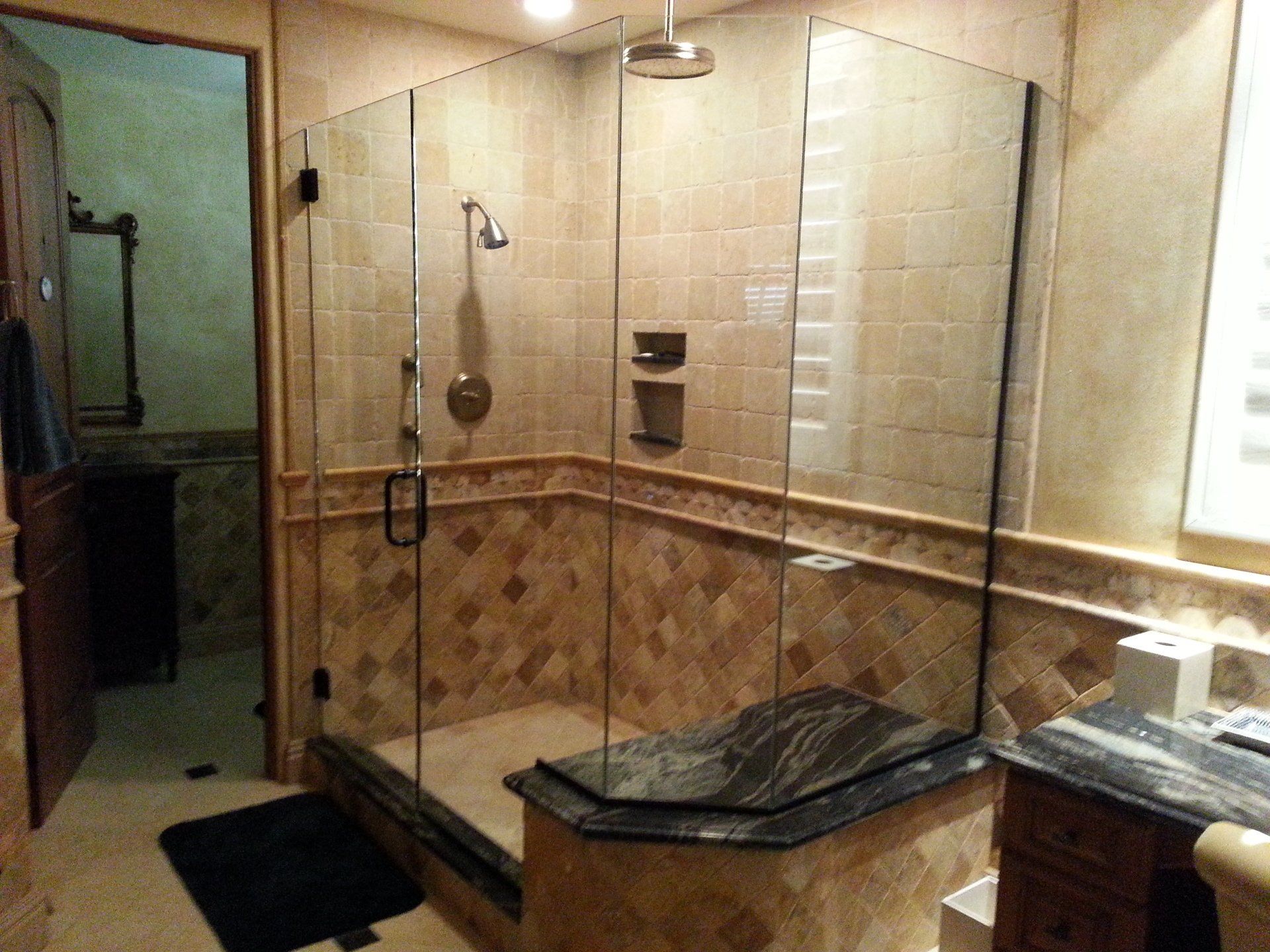 A bathroom with a walk in shower and a sink