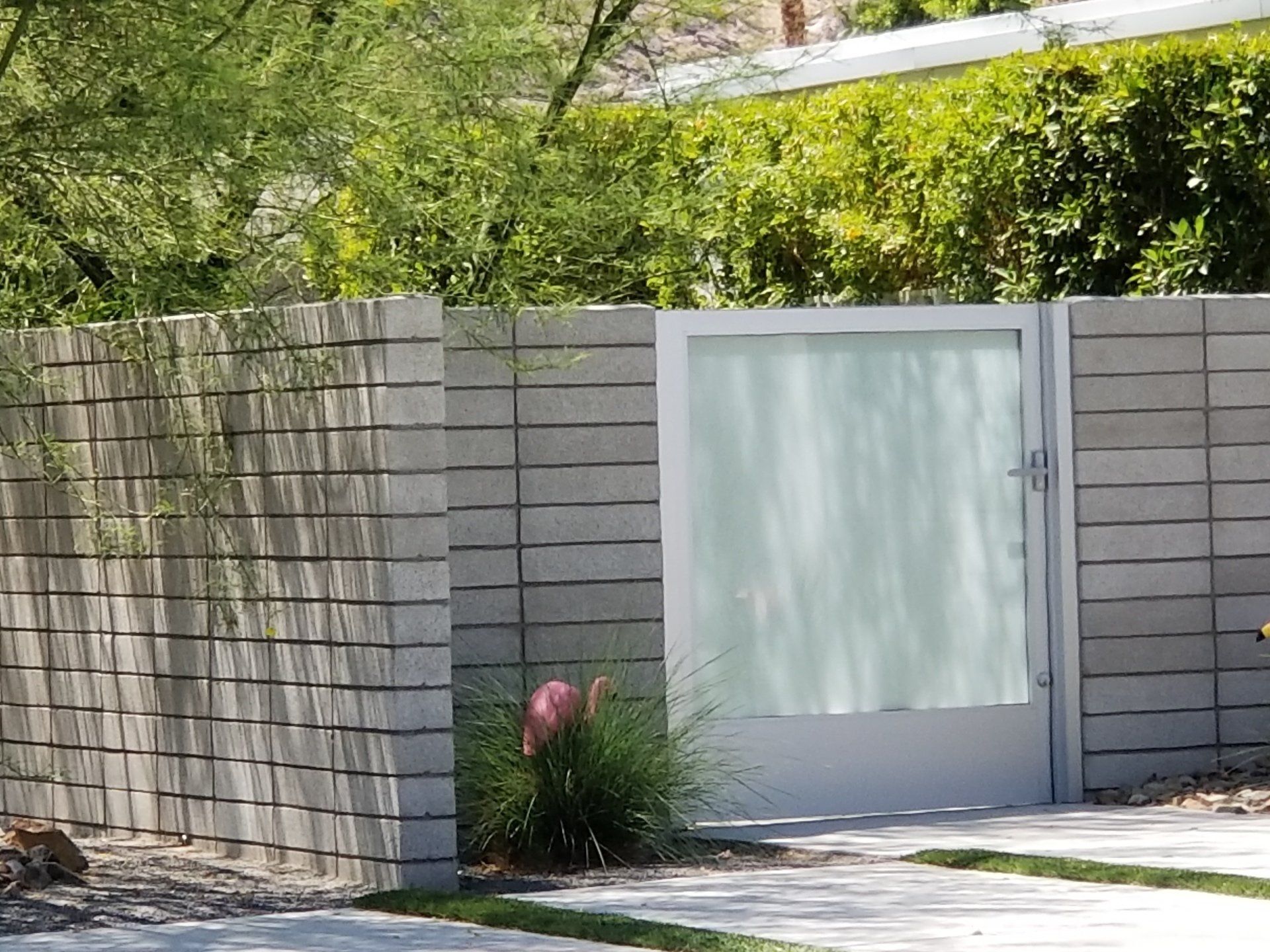 A brick fence with a white gate in front of it