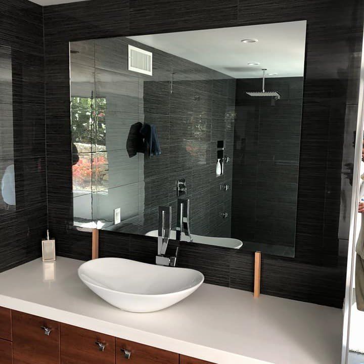 A bathroom with a sink and a large mirror.
