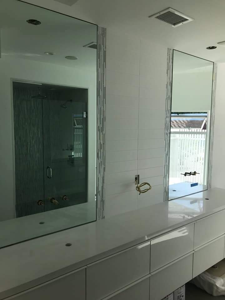 A bathroom with two mirrors and a sink.