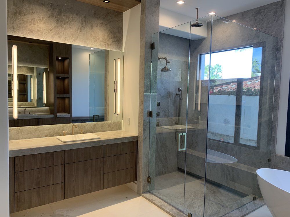 A bathroom with a walk in shower , sink , and mirror.