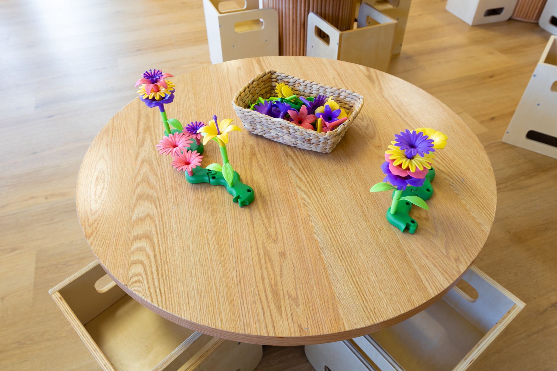 A wooden table with a basket of flowers on it.