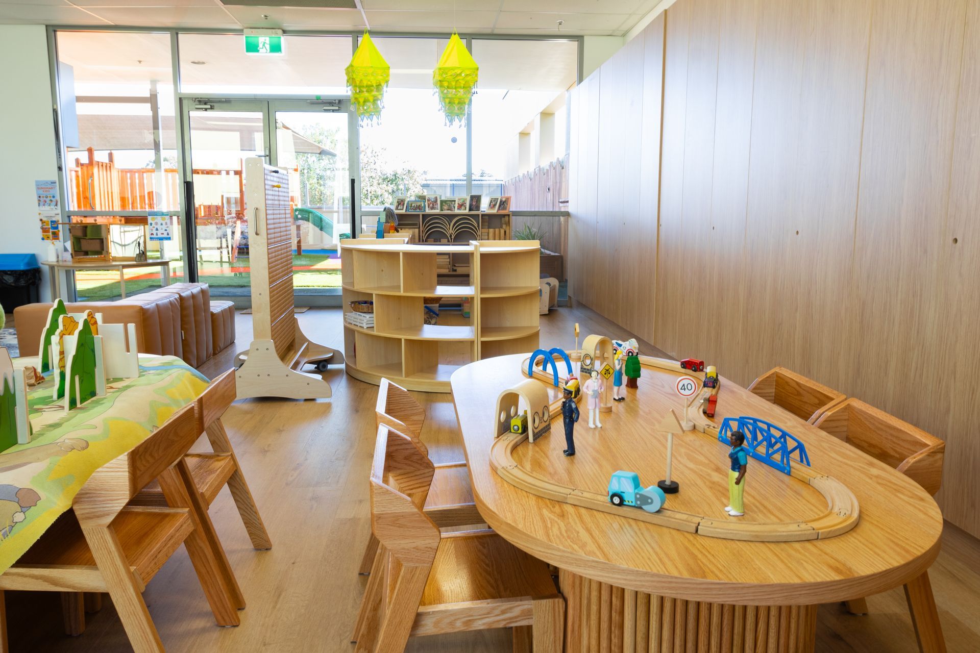 A room with a table and chairs and a train set on it.