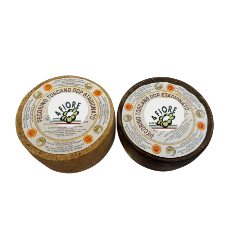 Due forme di formaggio Pecorino Toscano DOP, una più chiara e una più scura.