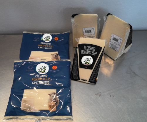 Confezioni di formaggio Pecorino Romano su una superficie argentata.
