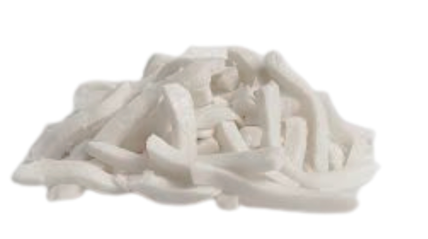 Pezzi di cocco bianco grattugiati ammucchiati insieme.