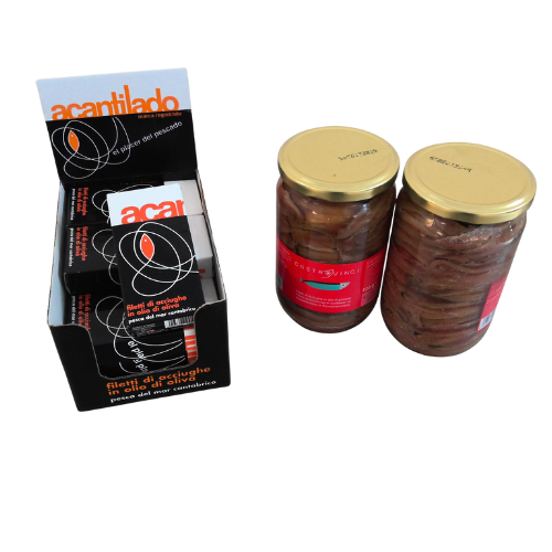 Esposizione di filetti di acciughe Acantilado in una scatola, con due barattoli di acciughe accanto.