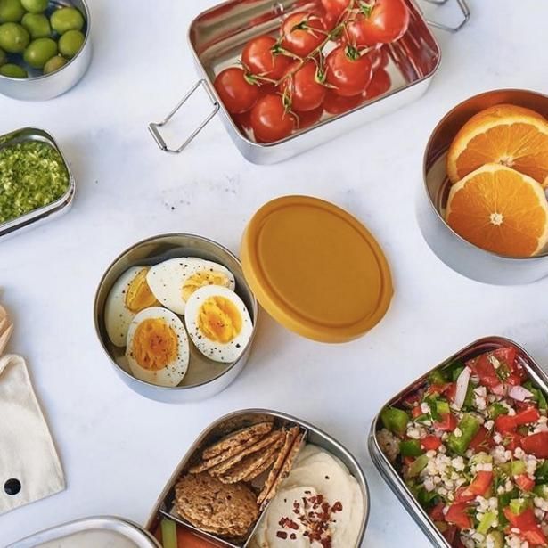 A Table Topped With Containers Of Food Including Hard Boiled Eggs Tomatoes And Oranges — The Real Grocer In Golden Beach, QLD
