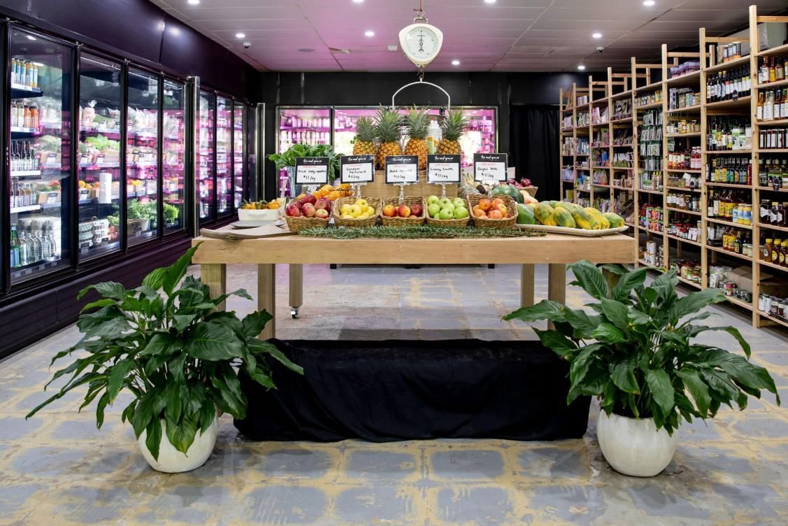 There Is A Table With Fruit On It In The Middle Of A Grocery Store — The Real Grocer In Golden Beach, QLD