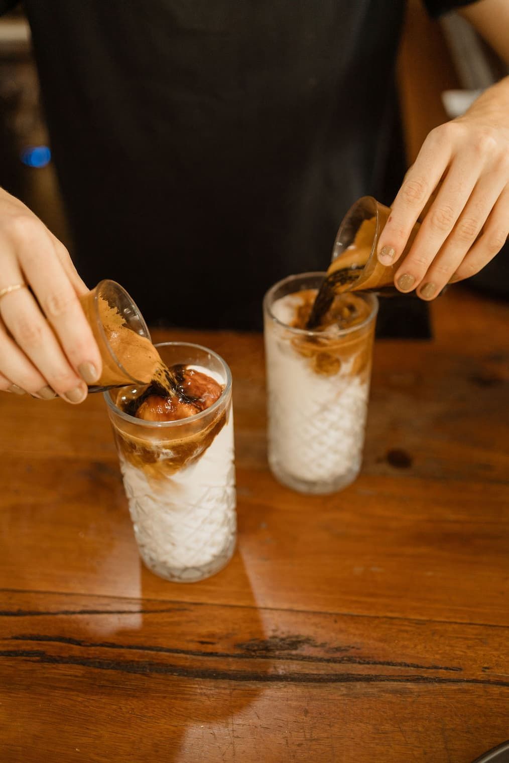 Two Espresso Shots Being Poured Into Glasses Of Milk — The Real Grocer In Golden Beach, QLD