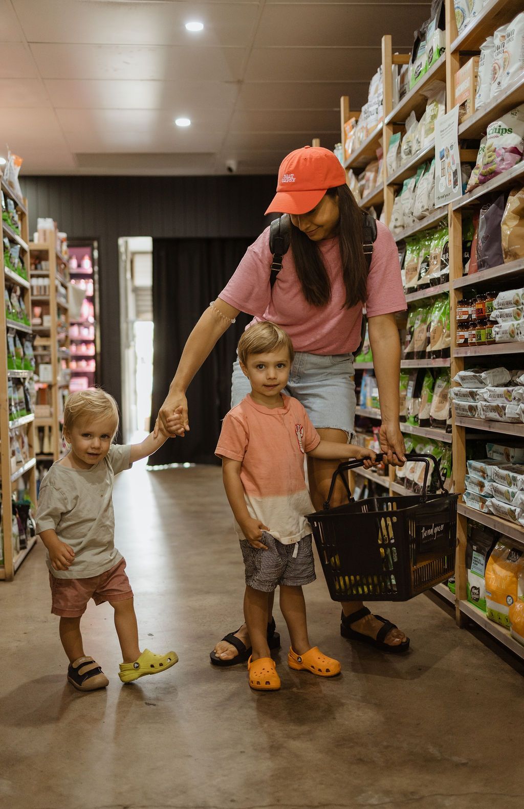 A Woman And Two Children Holding Hands In a Grocery Store — The Real Grocer In Golden Beach, QLD