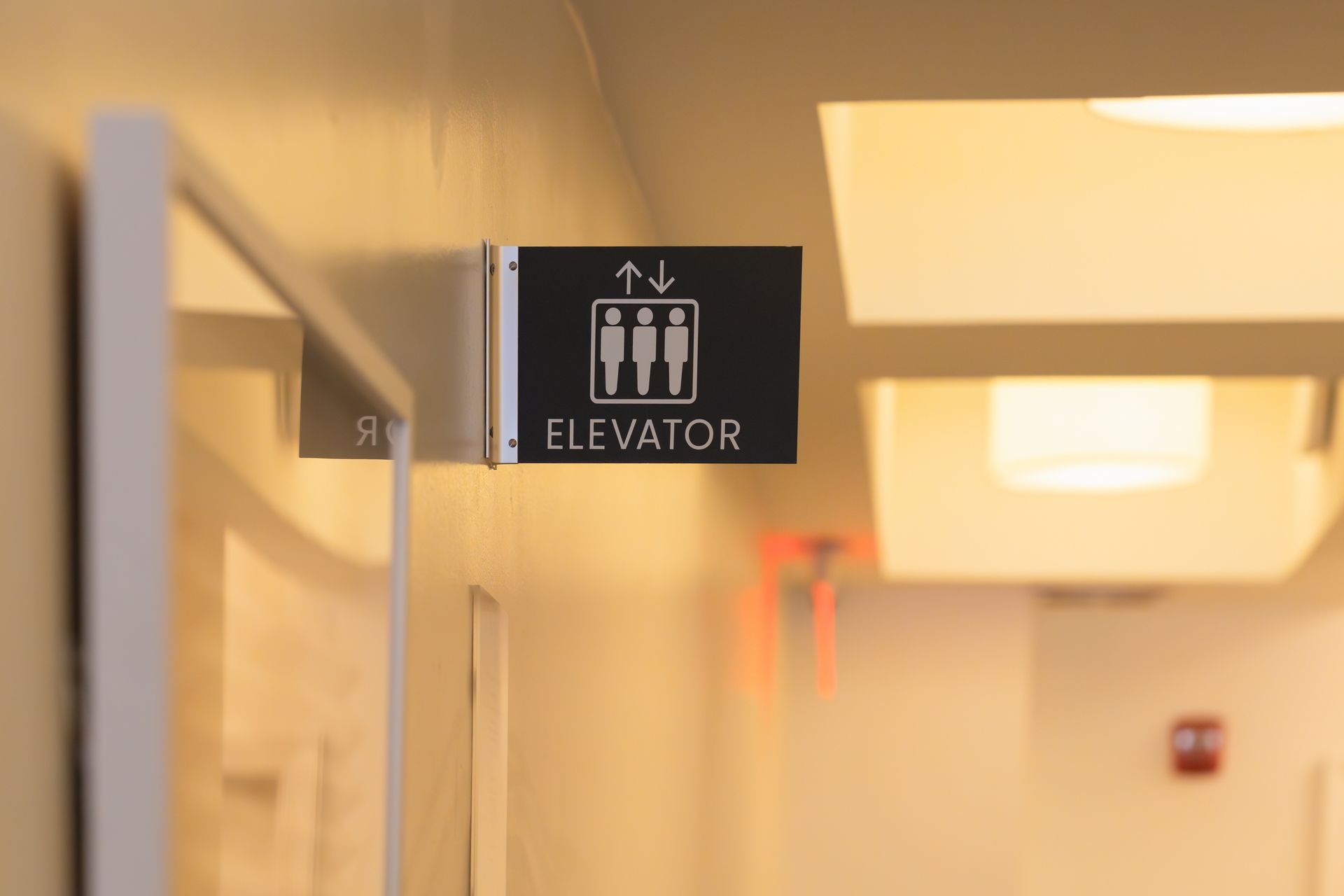 Elevator sign in a well-lit hallway.