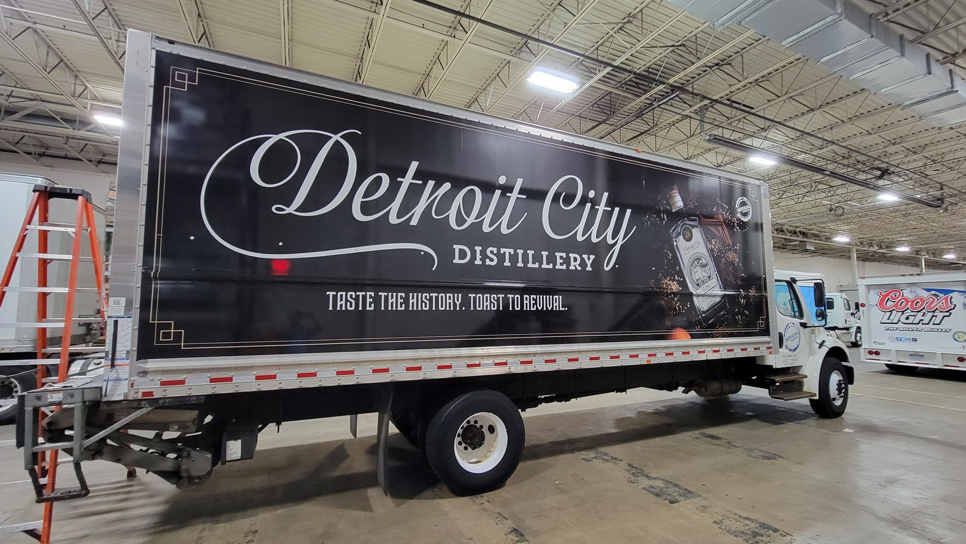 A detroit city distillery truck is parked in a warehouse.