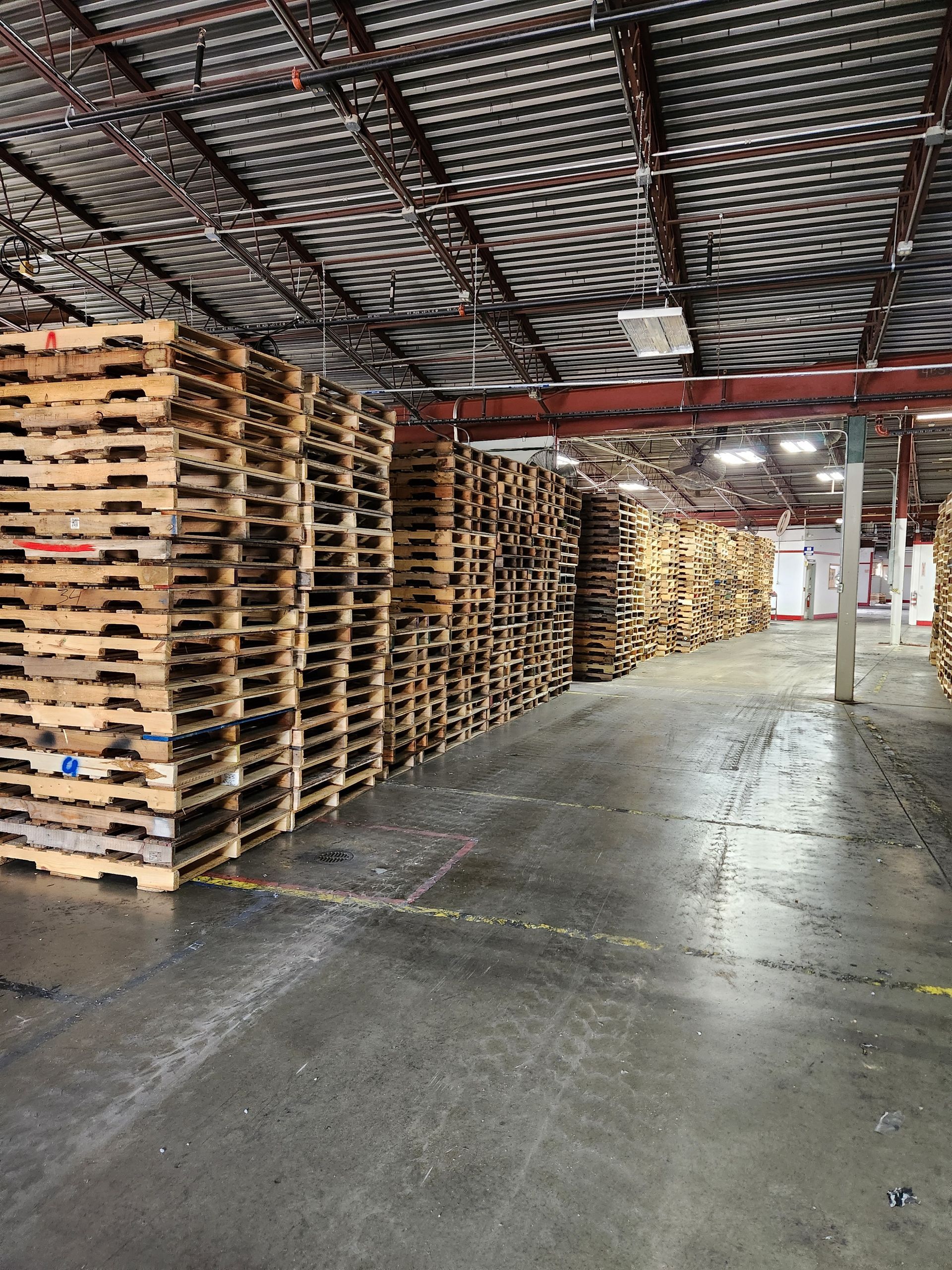 A warehouse filled with lots of wooden pallets